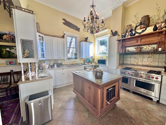 kitchen with white cabinets, pendant lighting, stainless steel appliances, and a kitchen island