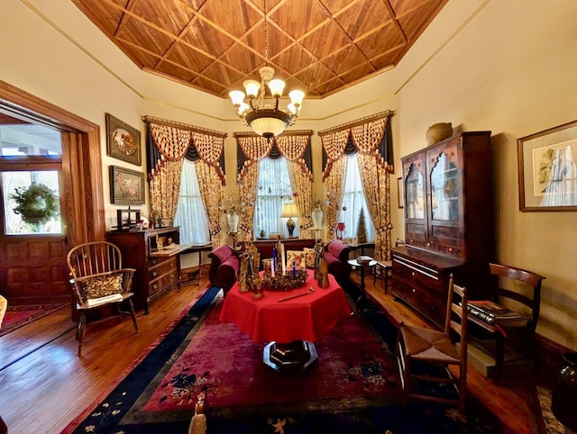 living area featuring hardwood / wood-style floors, a notable chandelier, and wood ceiling