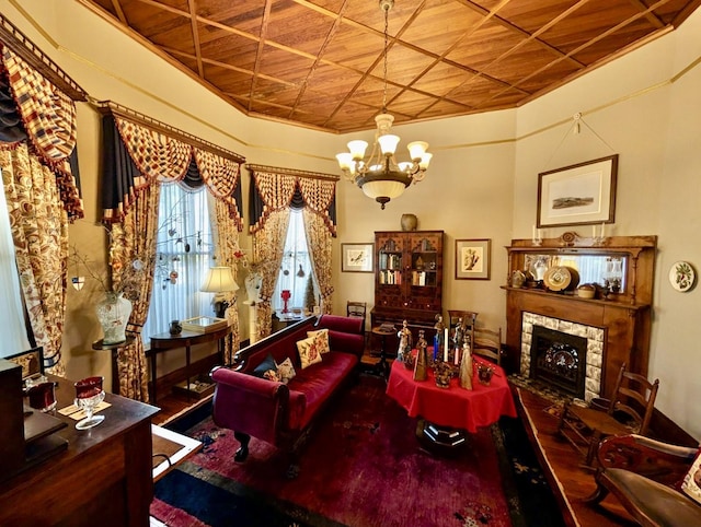 living room featuring a stone fireplace, wooden ceiling, and a notable chandelier