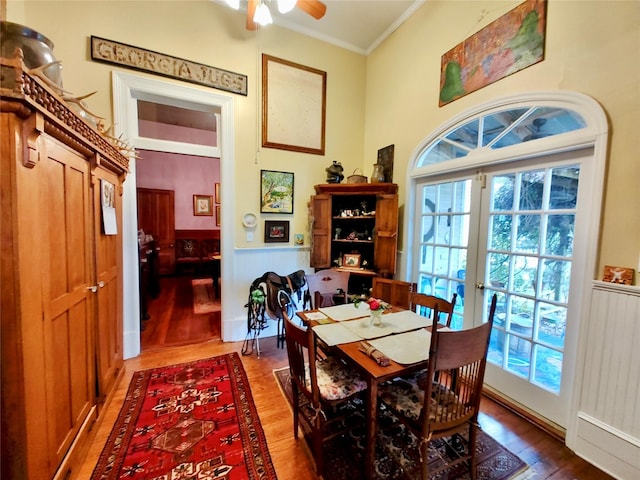 dining space featuring french doors, hardwood / wood-style flooring, ceiling fan, and crown molding