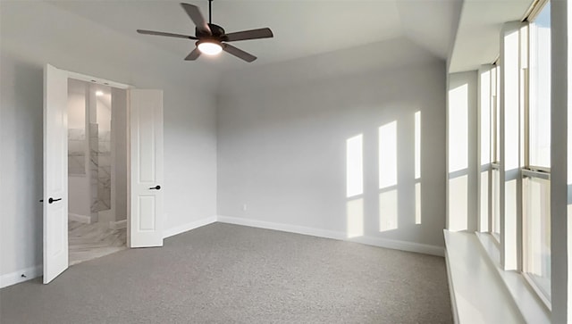 carpeted empty room with ceiling fan and lofted ceiling