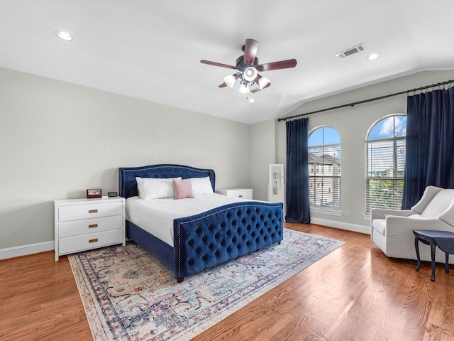 bedroom with ceiling fan, wood-type flooring, and vaulted ceiling