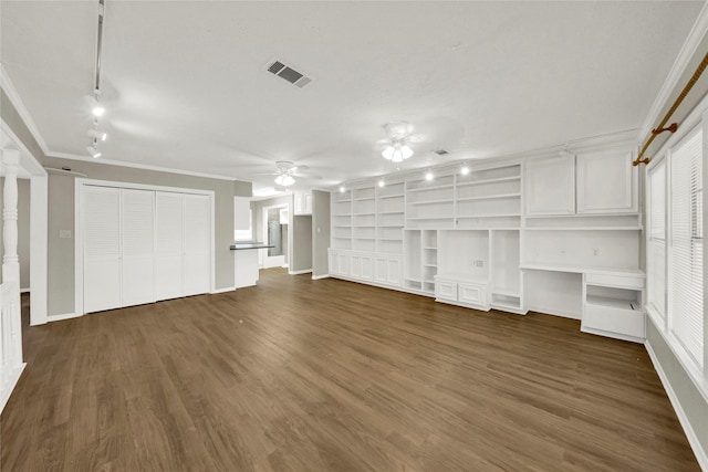 unfurnished living room with ceiling fan, dark hardwood / wood-style flooring, crown molding, and track lighting