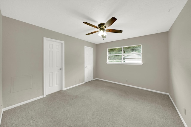 carpeted spare room featuring ceiling fan