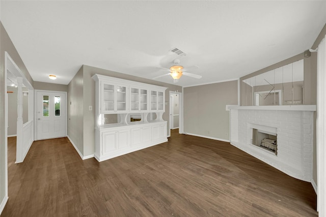 unfurnished living room featuring dark hardwood / wood-style floors, ceiling fan, and a brick fireplace