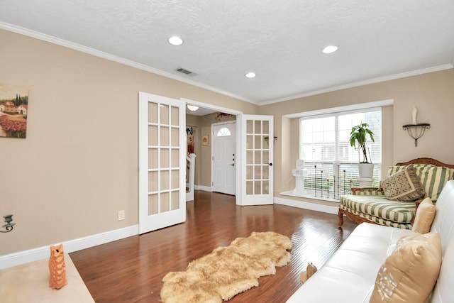 living room featuring a textured ceiling, french doors, dark hardwood / wood-style floors, and ornamental molding