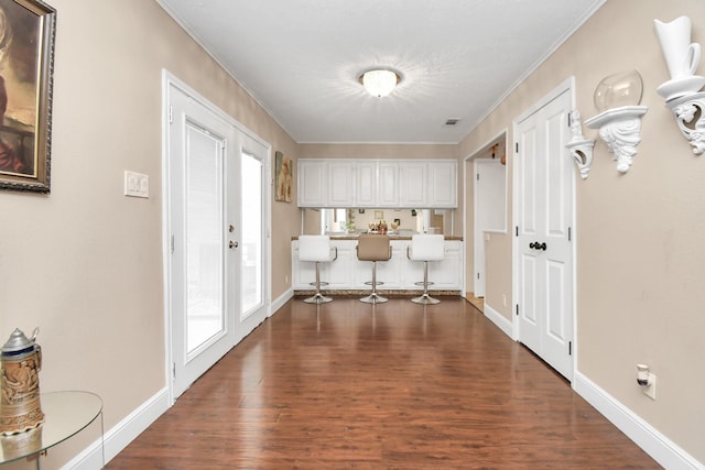 hall featuring french doors, dark hardwood / wood-style floors, and ornamental molding