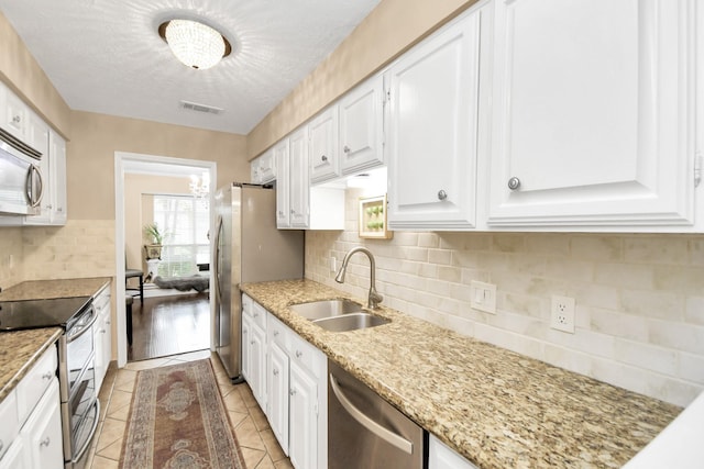 kitchen with white cabinets, appliances with stainless steel finishes, decorative backsplash, and sink