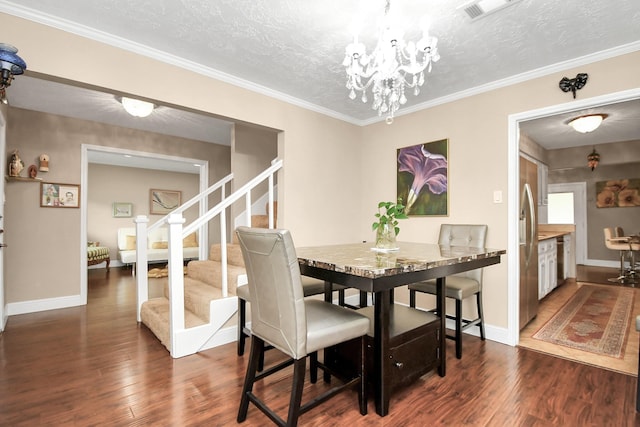 dining room with crown molding, dark hardwood / wood-style floors, a textured ceiling, and a notable chandelier