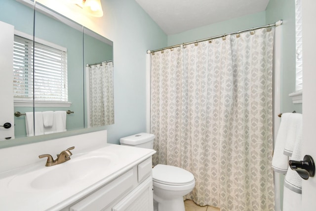 bathroom featuring a shower with shower curtain, vanity, and toilet