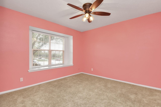 spare room with light colored carpet and ceiling fan