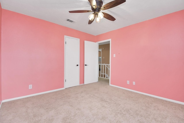 carpeted spare room with ceiling fan