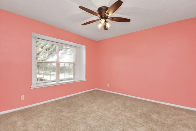 carpeted spare room with ceiling fan