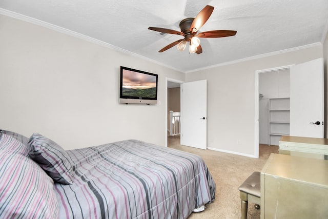 bedroom with a spacious closet, ceiling fan, light colored carpet, and ornamental molding