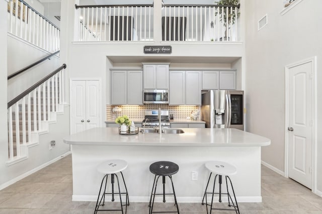 kitchen featuring a kitchen breakfast bar, stainless steel appliances, and a high ceiling