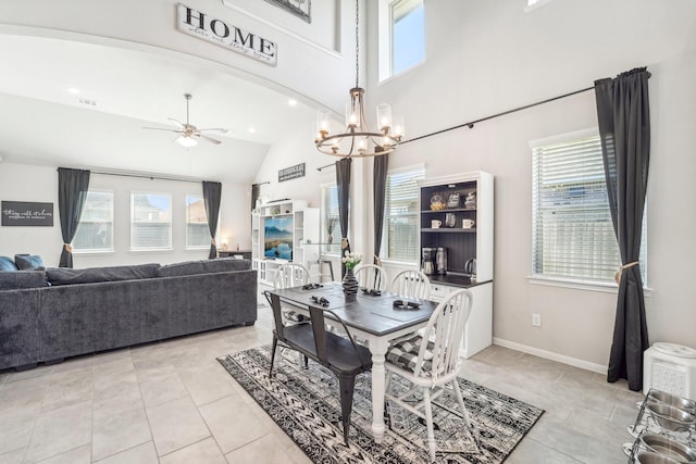 dining area featuring light tile patterned floors, ceiling fan with notable chandelier, high vaulted ceiling, and a wealth of natural light