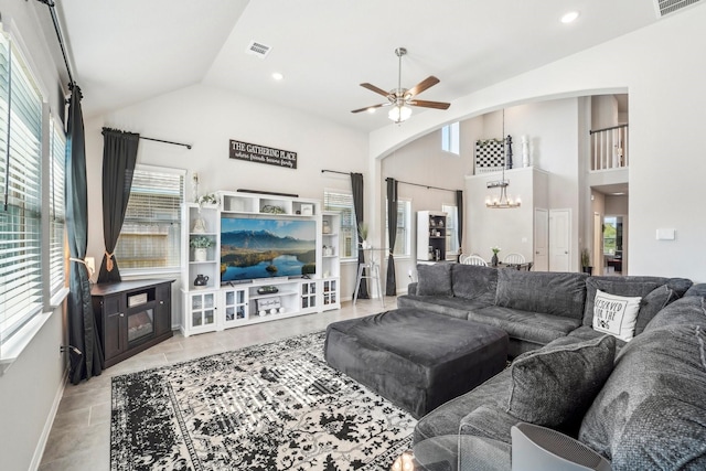 living room featuring ceiling fan with notable chandelier and lofted ceiling