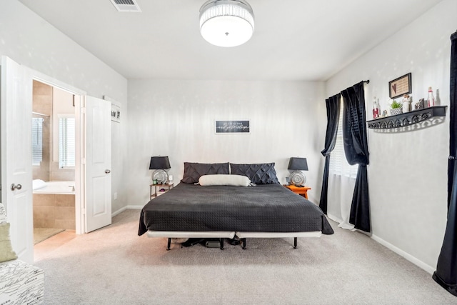 carpeted bedroom featuring ensuite bath