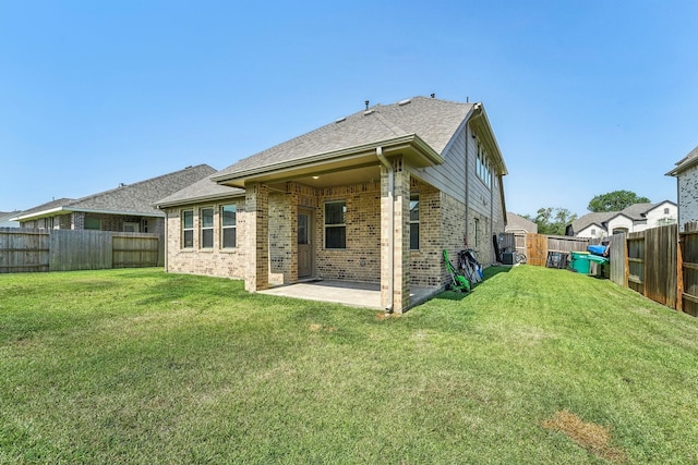 back of house featuring a lawn and a patio