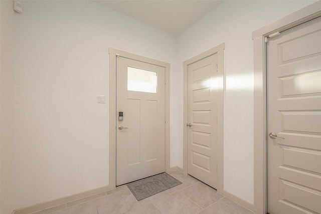 doorway to outside featuring light tile patterned floors and baseboards