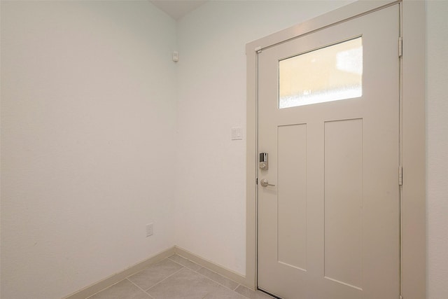 foyer entrance with light tile patterned floors and baseboards