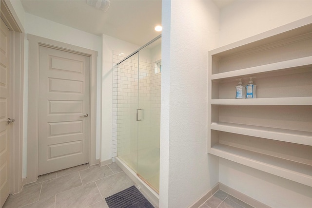 full bath with tile patterned floors, a shower stall, and baseboards