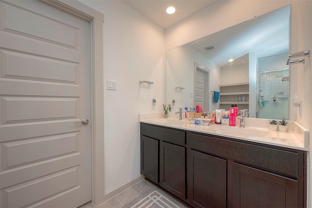 bathroom featuring a sink, visible vents, a stall shower, and double vanity