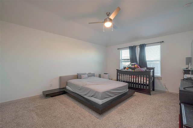 bedroom featuring baseboards, light carpet, a ceiling fan, and vaulted ceiling