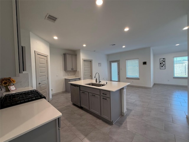 kitchen featuring visible vents, gray cabinets, a sink, light countertops, and dishwasher