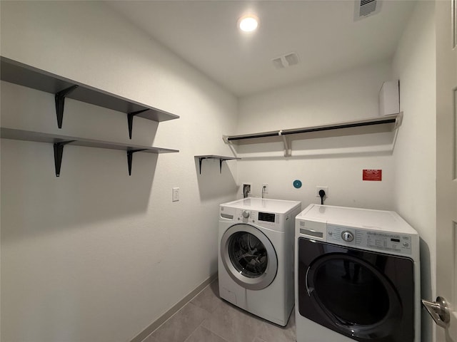 laundry area with laundry area, washing machine and dryer, visible vents, and baseboards