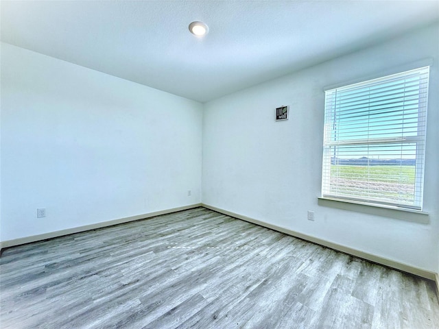 unfurnished room featuring wood finished floors and baseboards