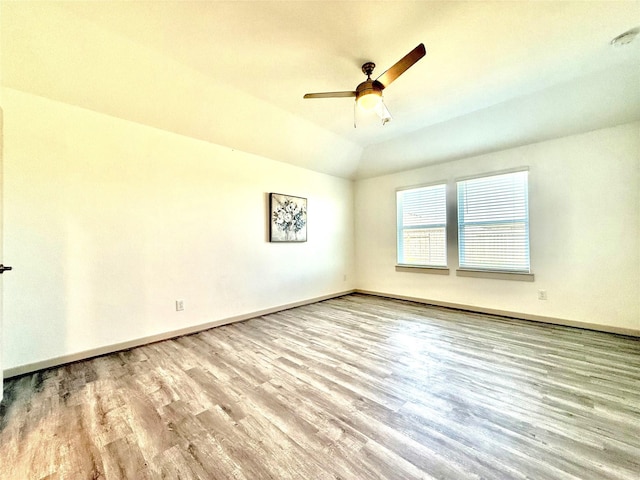 unfurnished room with vaulted ceiling, wood finished floors, baseboards, and ceiling fan