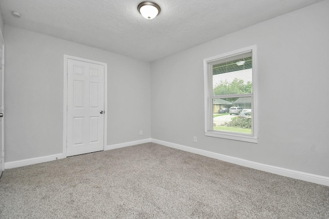 carpeted empty room with a textured ceiling