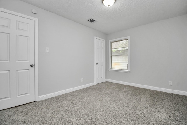 carpeted spare room with a textured ceiling