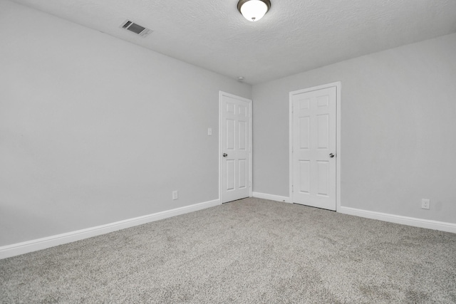 spare room featuring carpet and a textured ceiling