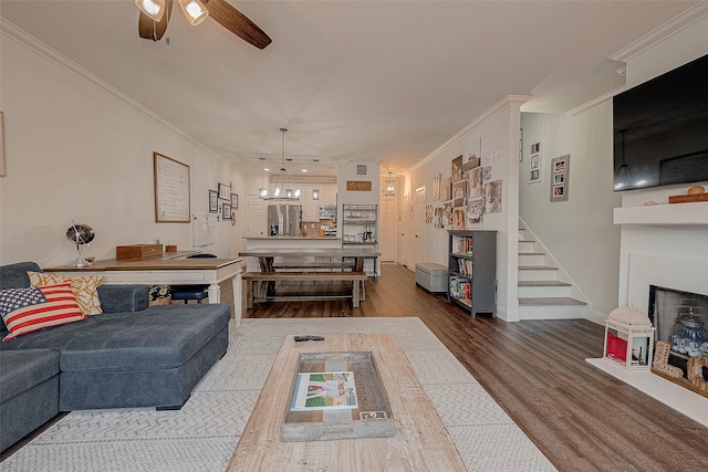 living room with ceiling fan, wood-type flooring, and ornamental molding