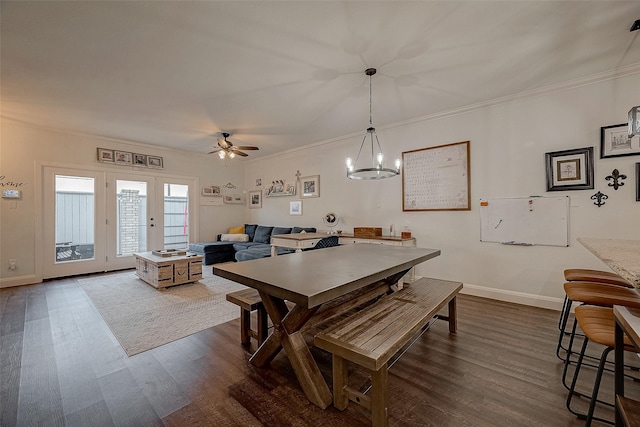 dining space with ceiling fan with notable chandelier, dark hardwood / wood-style flooring, and ornamental molding