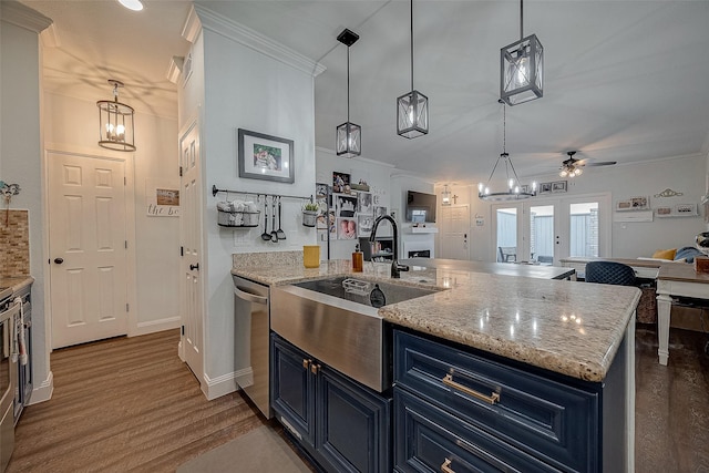 kitchen with stainless steel dishwasher, blue cabinets, a kitchen island with sink, ceiling fan, and sink