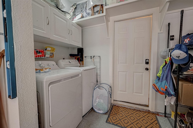 washroom with cabinets and washer and dryer