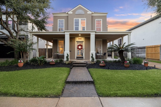 view of front of house with covered porch and a yard