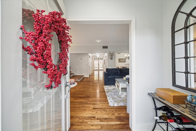 foyer entrance with hardwood / wood-style flooring and crown molding