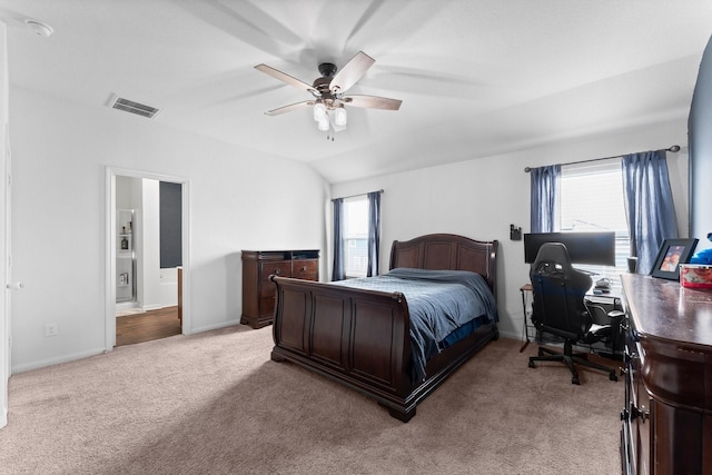 bedroom featuring ceiling fan, lofted ceiling, light carpet, and connected bathroom