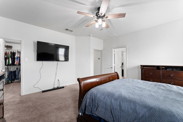 carpeted bedroom with ceiling fan, a closet, and a spacious closet