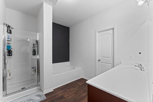 bathroom with hardwood / wood-style floors, vanity, and independent shower and bath