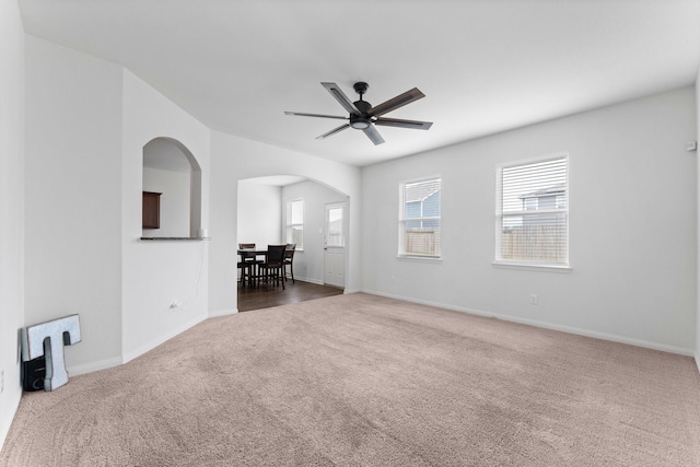 unfurnished room with dark colored carpet and ceiling fan