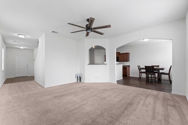 carpeted living room with ceiling fan