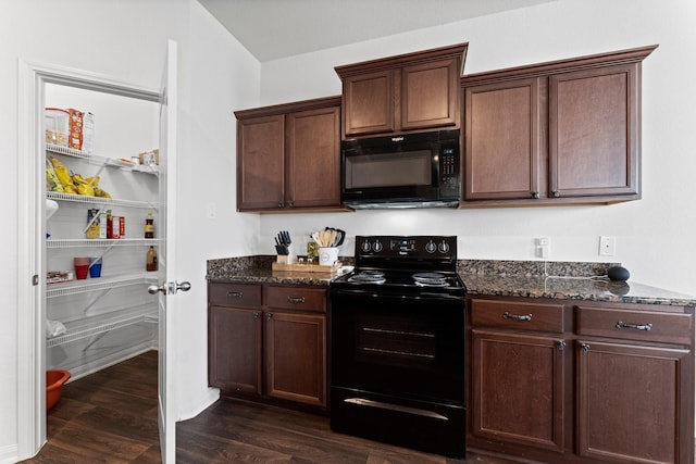 kitchen with black appliances, dark hardwood / wood-style floors, dark brown cabinets, and dark stone counters