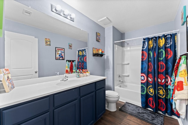 full bathroom featuring shower / bath combo with shower curtain, vanity, hardwood / wood-style floors, and toilet