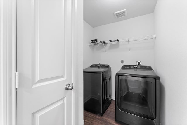 laundry area featuring washer and dryer and dark hardwood / wood-style floors