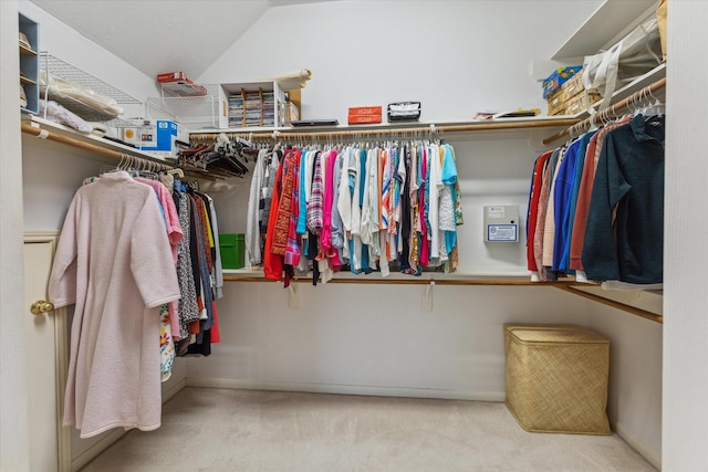 spacious closet with carpet flooring and vaulted ceiling